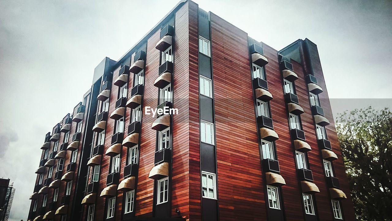 LOW ANGLE VIEW OF APARTMENT BUILDING AGAINST SKY