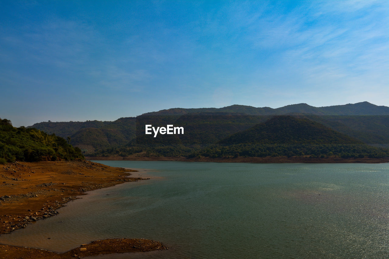 Scenic view of sea and mountains against sky