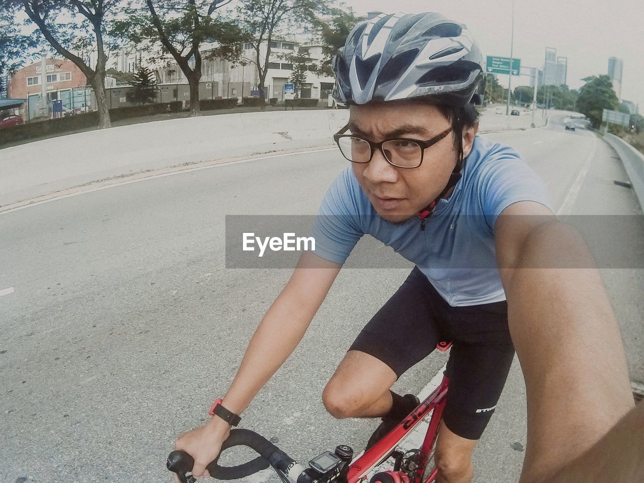 MIDSECTION OF MAN RIDING BICYCLE ON STREET