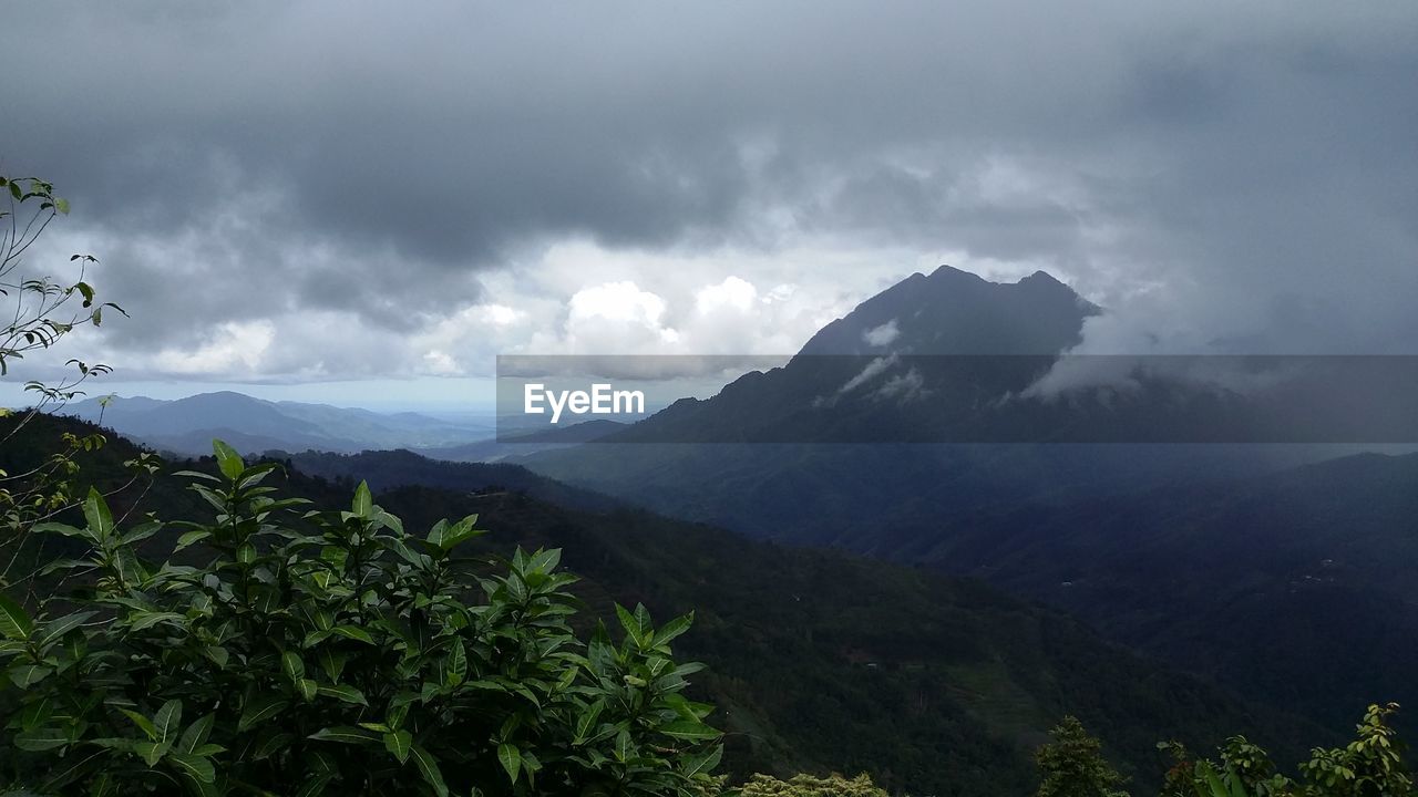 SCENIC VIEW OF MOUNTAINS AGAINST CLOUDY SKY