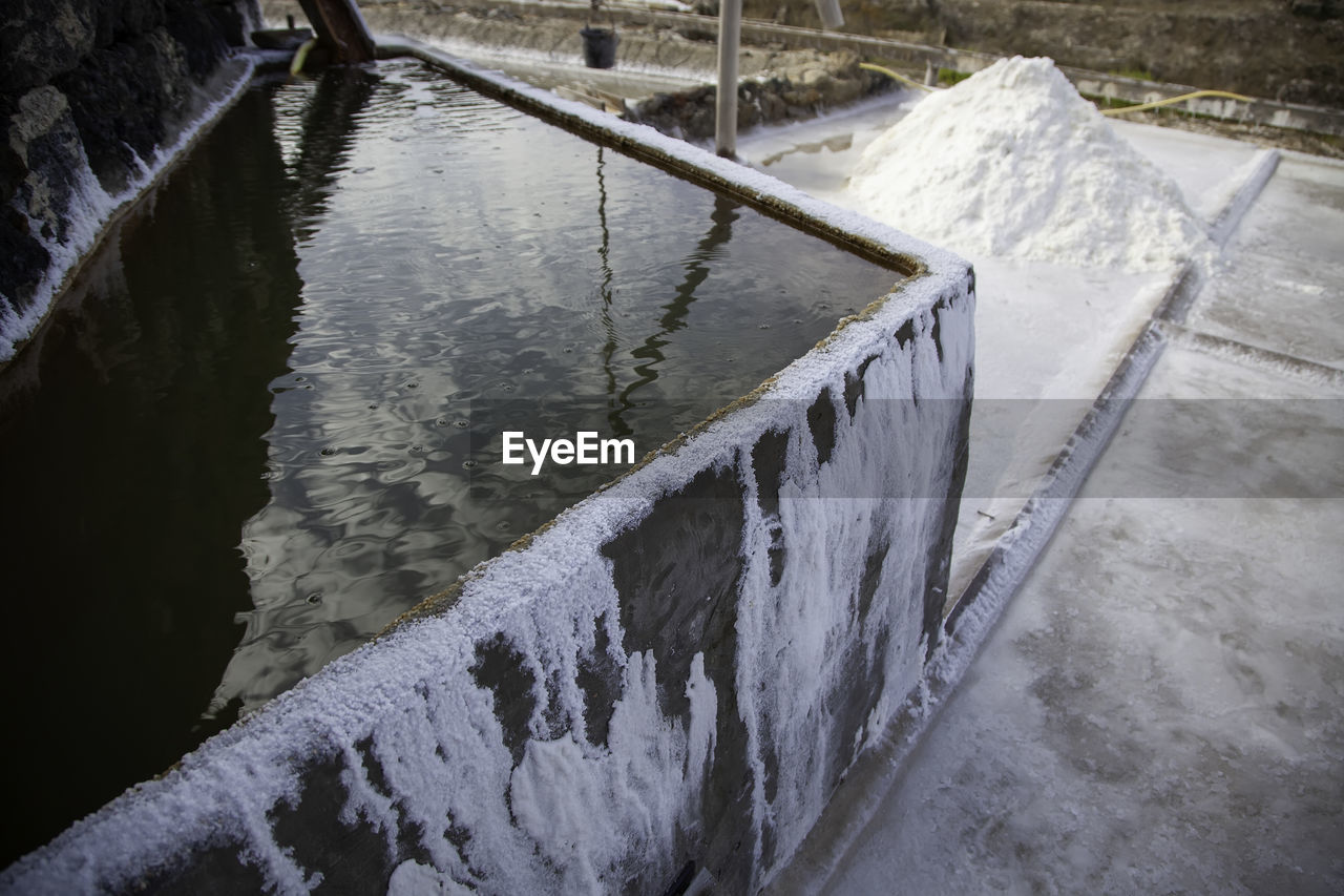 HIGH ANGLE VIEW OF FROZEN LAKE BY RAILING