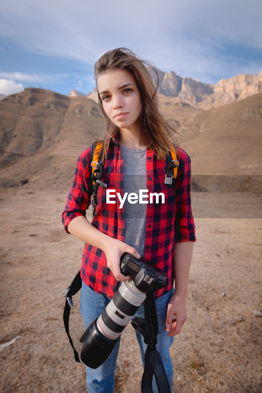 Beautiful young woman standing on land