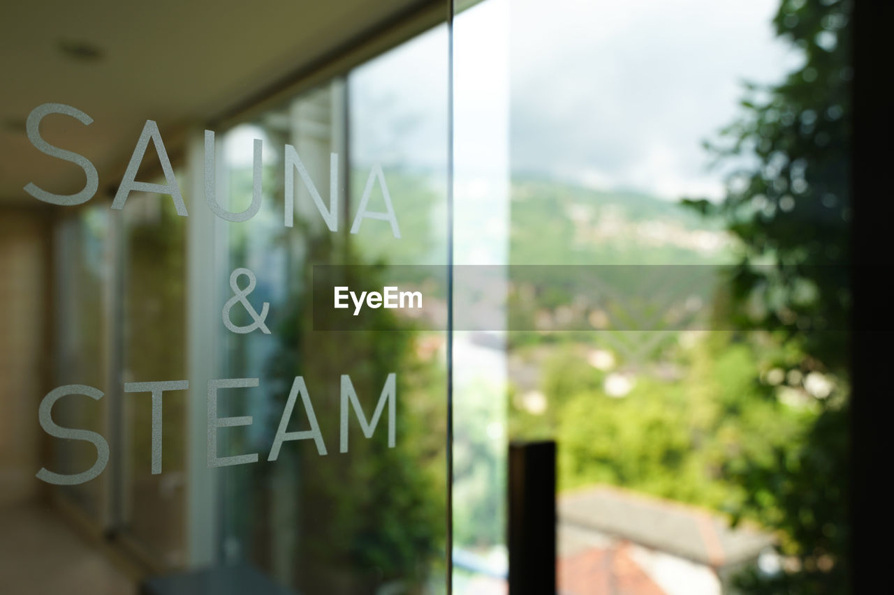Close-up of text sauna and steam on glass window