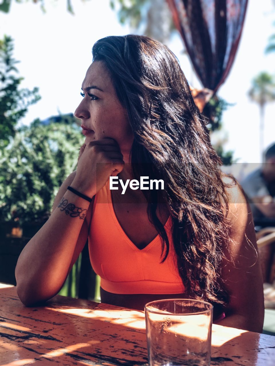 Young woman looking away while sitting at restaurant