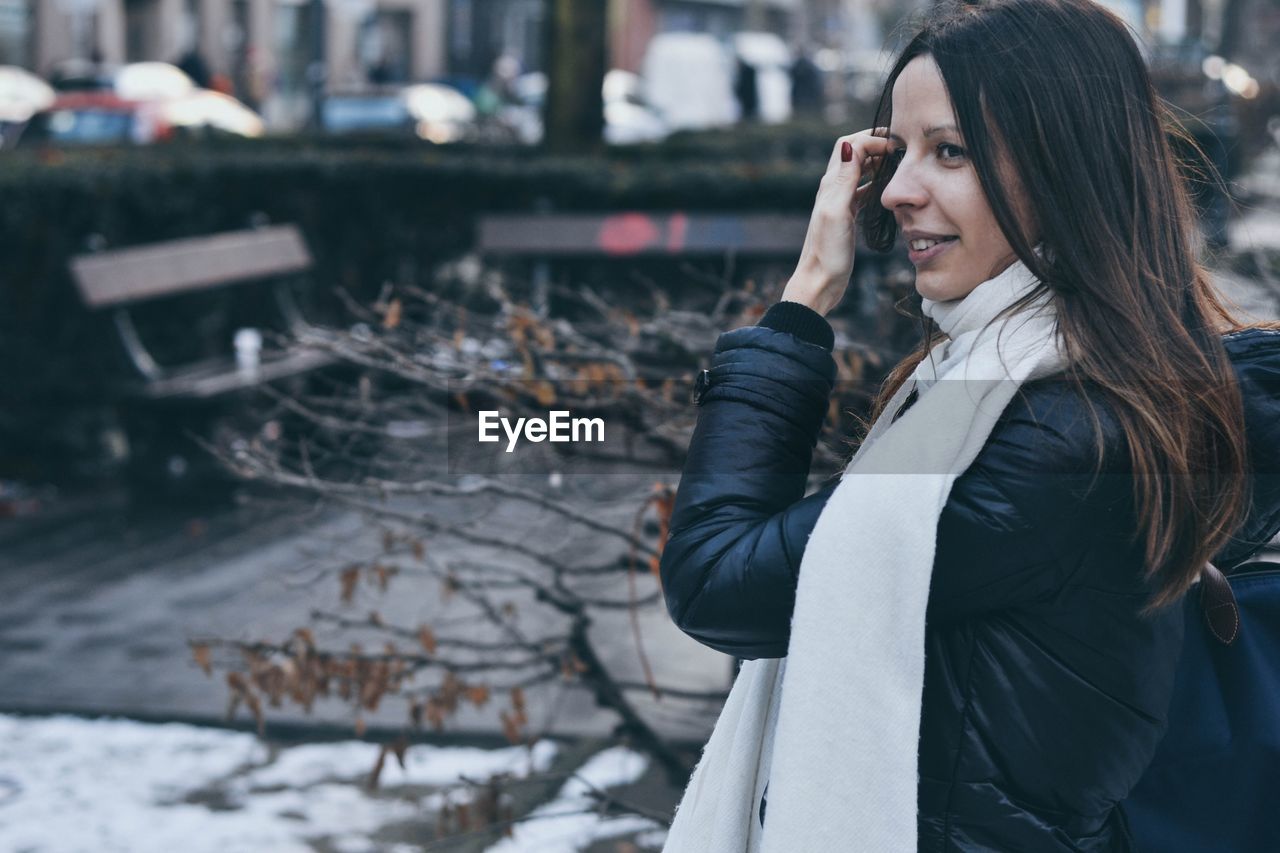 Woman smiling while standing outdoors during winter