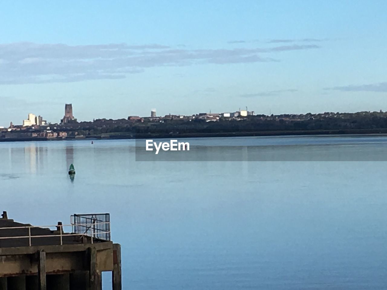 VIEW OF CALM RIVER IN FRONT OF BUILDINGS