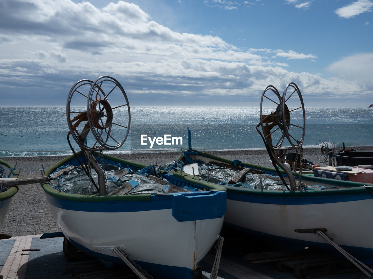 VIEW OF BOATS MOORED ON BEACH AGAINST SKY