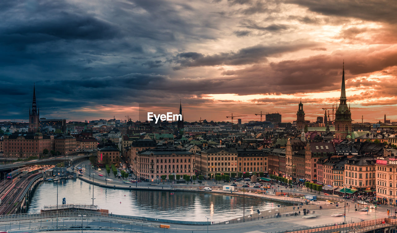 Aerial view of cityscape against cloudy sky