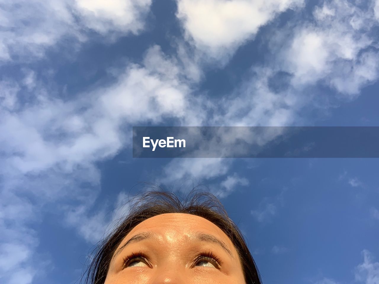 Low angle of woman looking up against sky