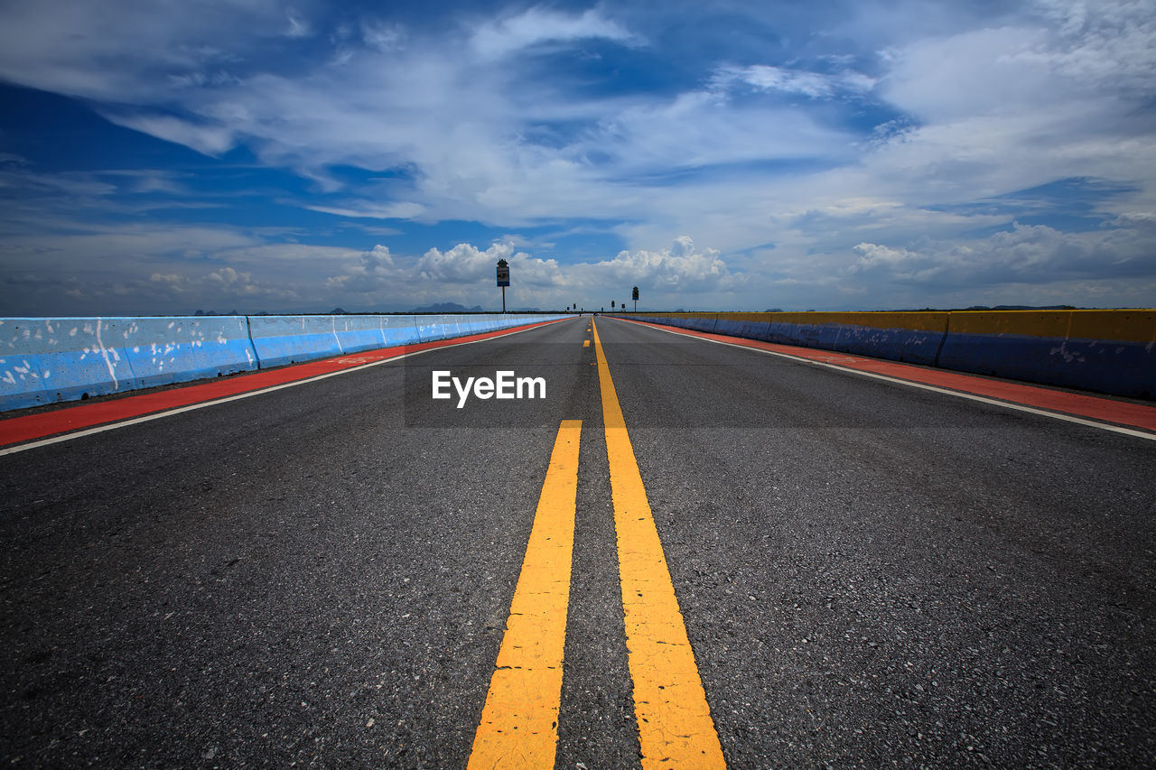 Empty road against cloudy sky