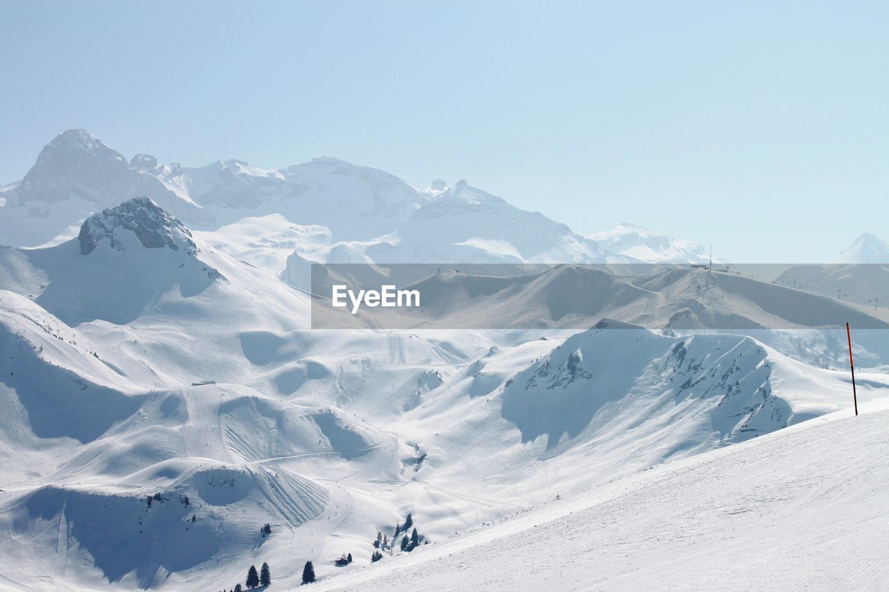 Scenic view of snowcapped mountains against clear sky