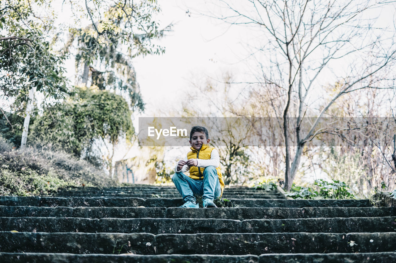 Portrait of boy sitting on staircase