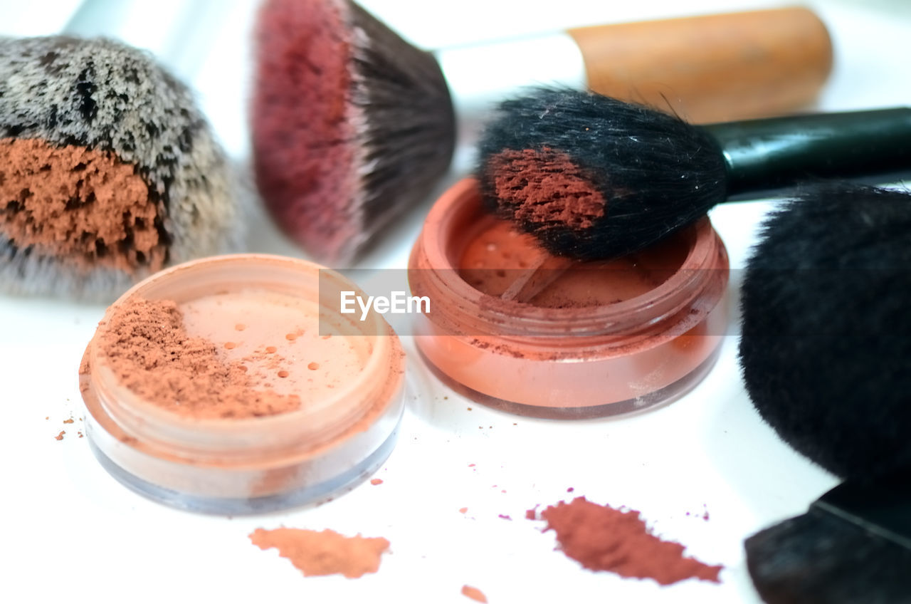 Close-up of eyeshadow and make-up brushes on table