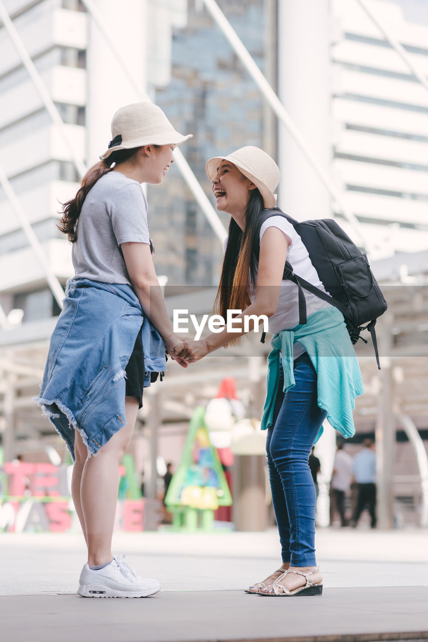 Tourists standing on footpath in city