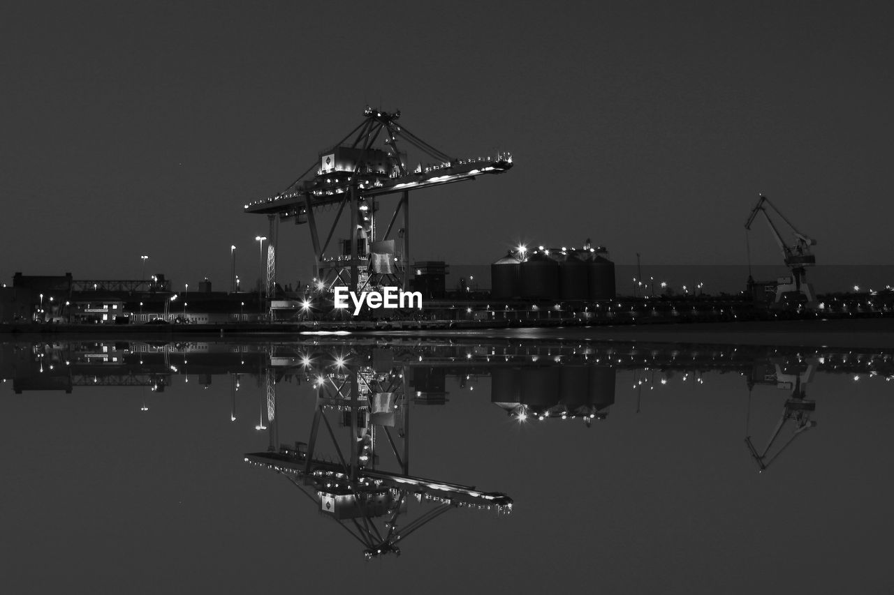 Harbor cranes reflecting in water