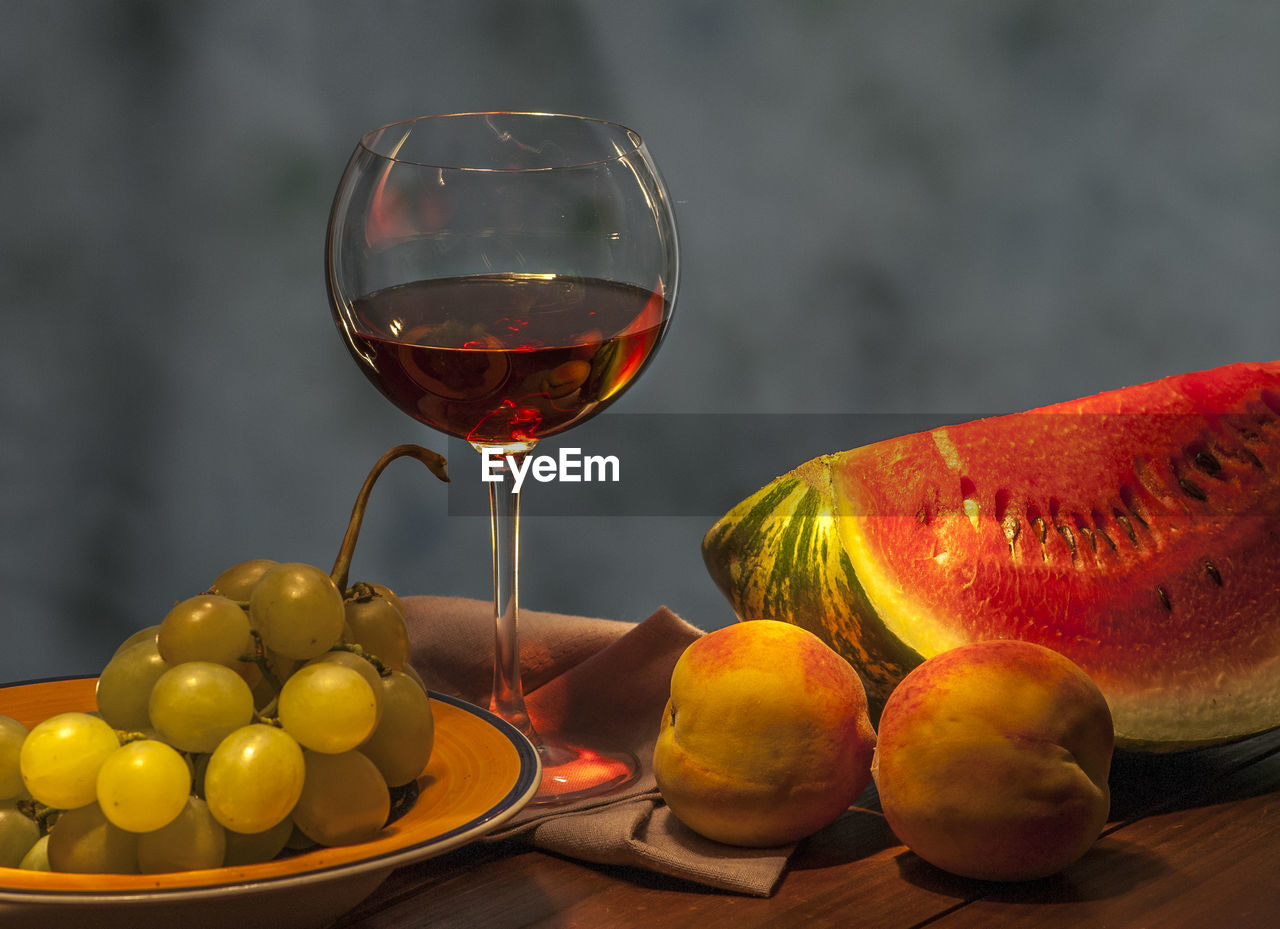 Close-up of wineglass with fruits on table