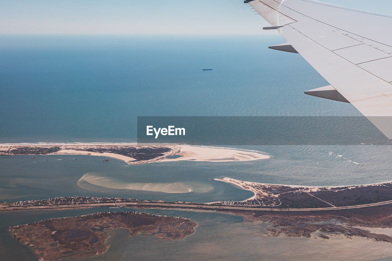 cropped image of airplane wing against clear sky