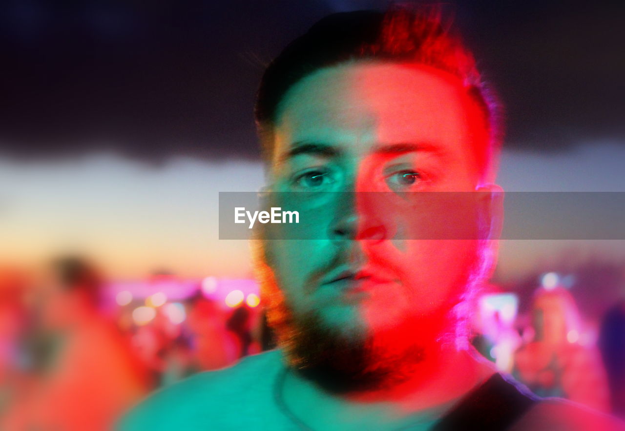 CLOSE-UP PORTRAIT OF MAN AGAINST BLURRED BACKGROUND