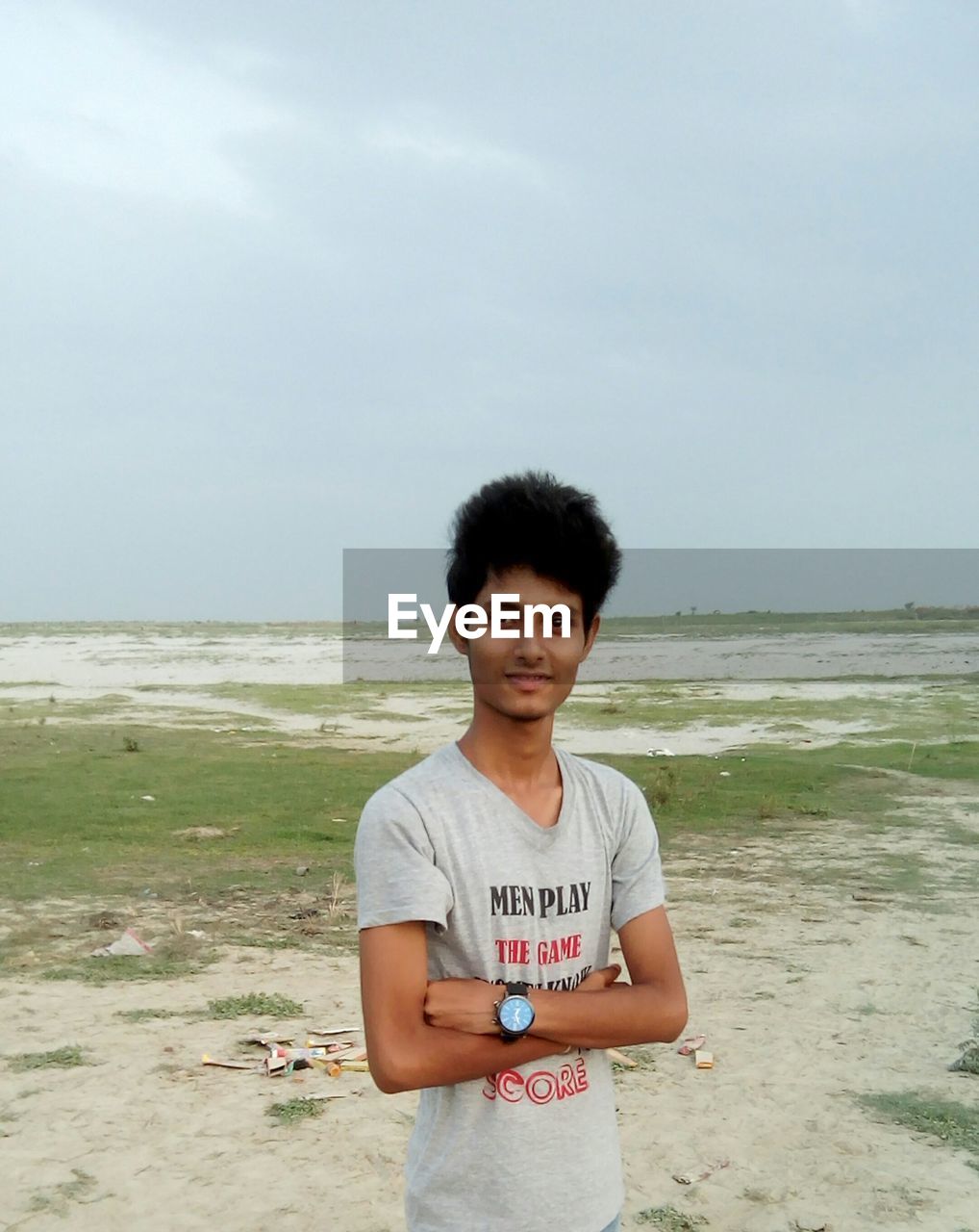 Portrait of young man standing at beach