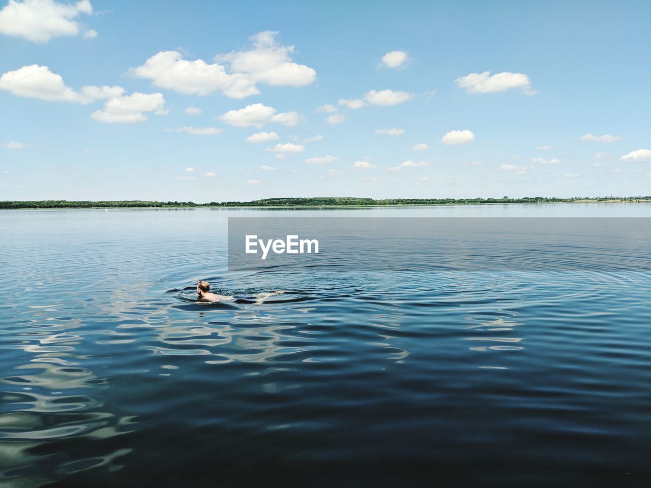 VIEW OF A SWIMMING IN LAKE