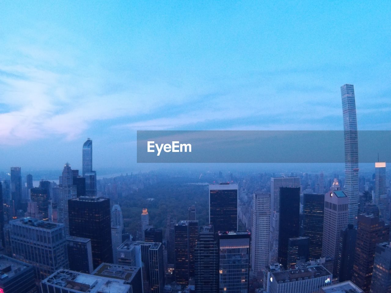 Cityscape against sky in foggy weather during sunrise