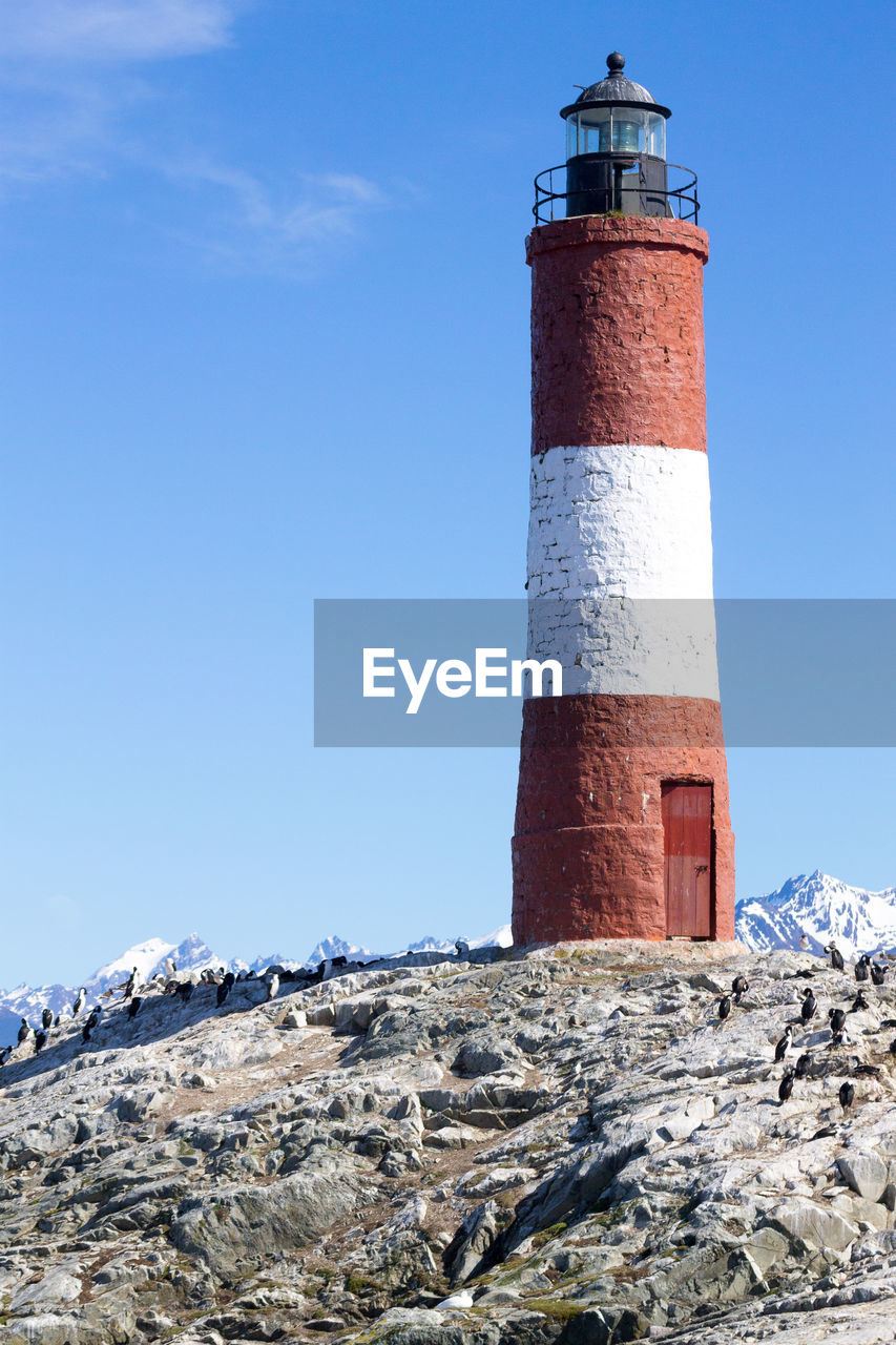 LOW ANGLE VIEW OF LIGHTHOUSE BY BUILDING AGAINST SKY