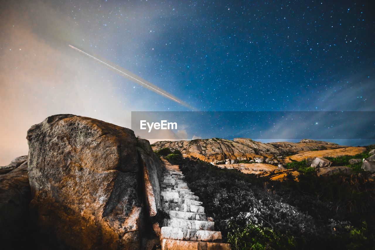 Low angle view of rock formation against sky at night