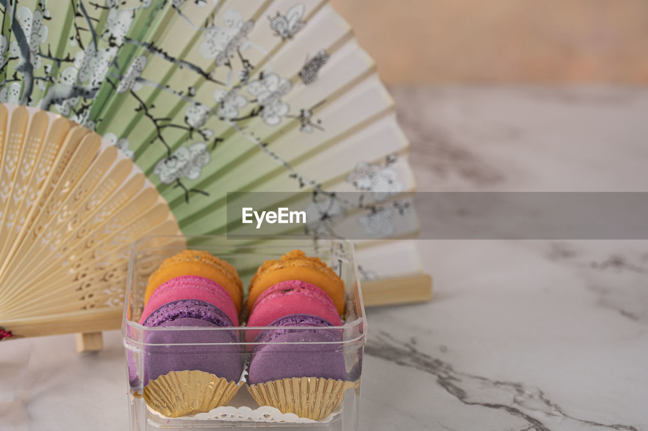 A few delicious macaroon, a famous french dessert with paper hand fan. 