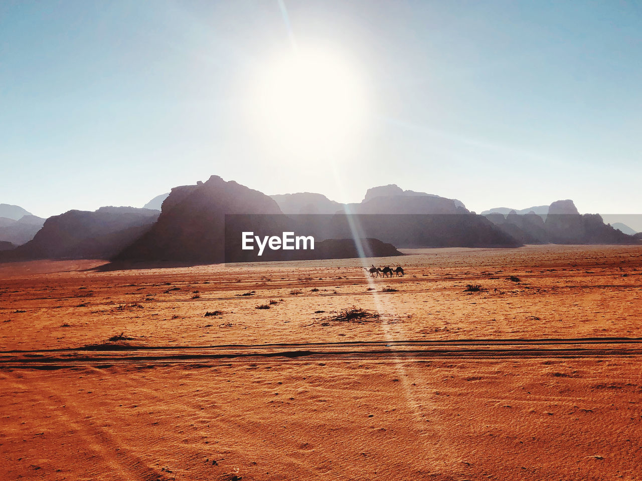 Scenic view of desert against sky on sunny day