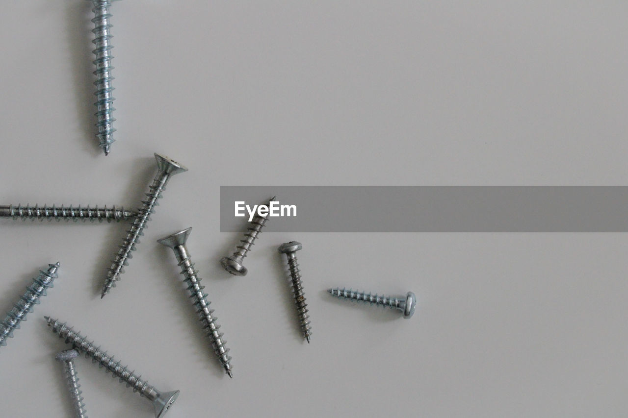 High angle view of screws against white background