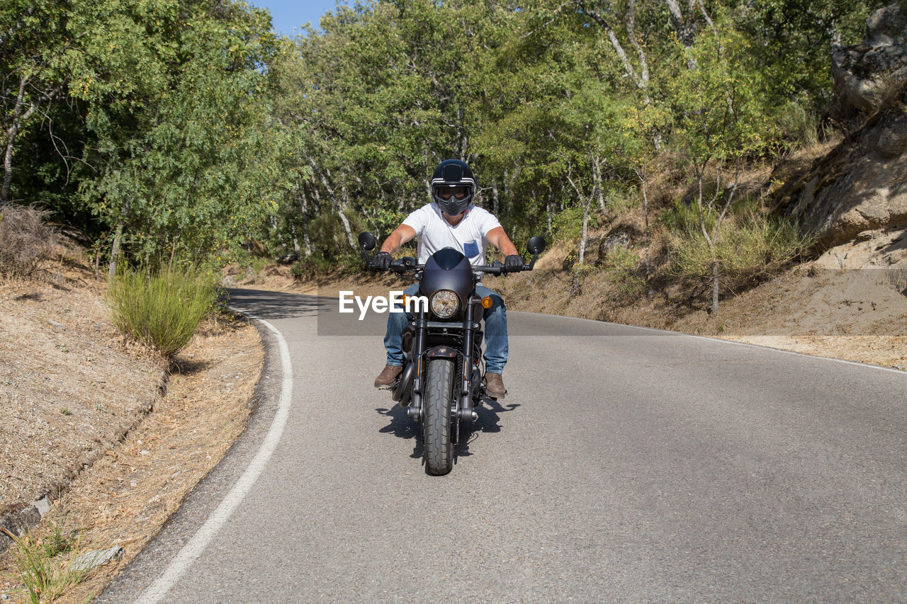 Young man riding motorcycle on road