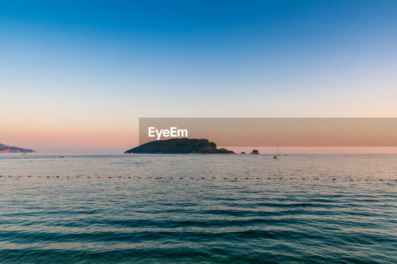 Scenic view of sea against clear sky during sunset