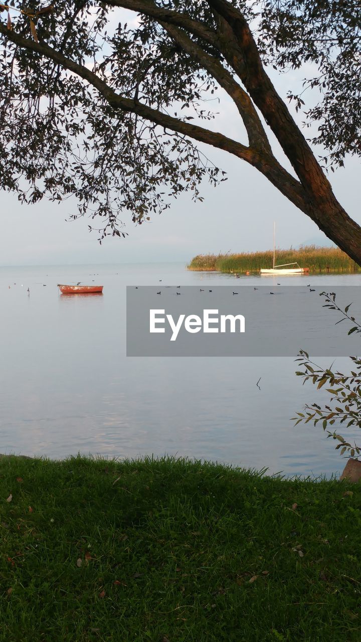 VIEW OF CALM LAKE AGAINST SKY