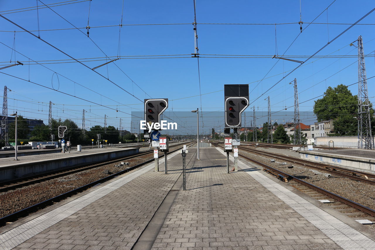 Railroad station platform against clear blue sky