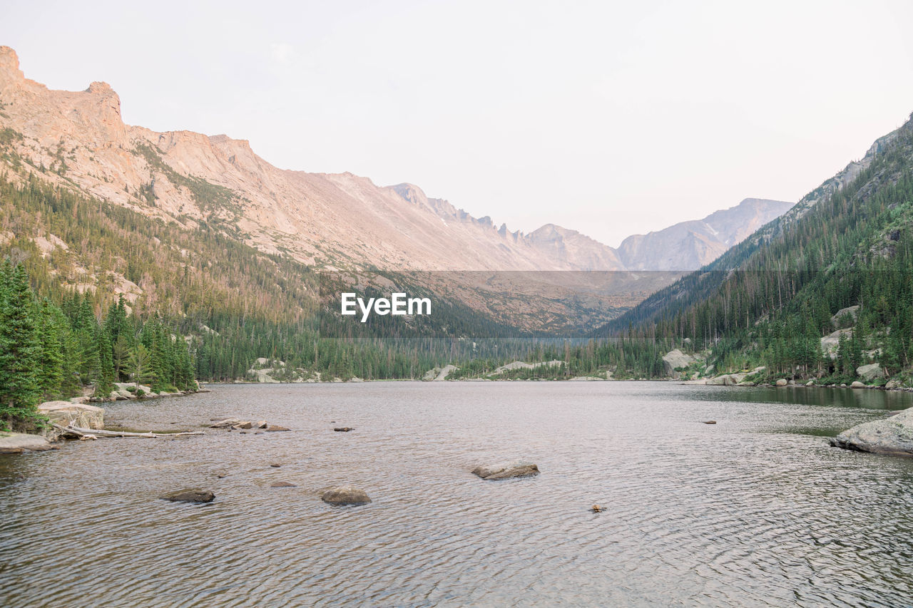 Scenic view of lake by mountains against sky