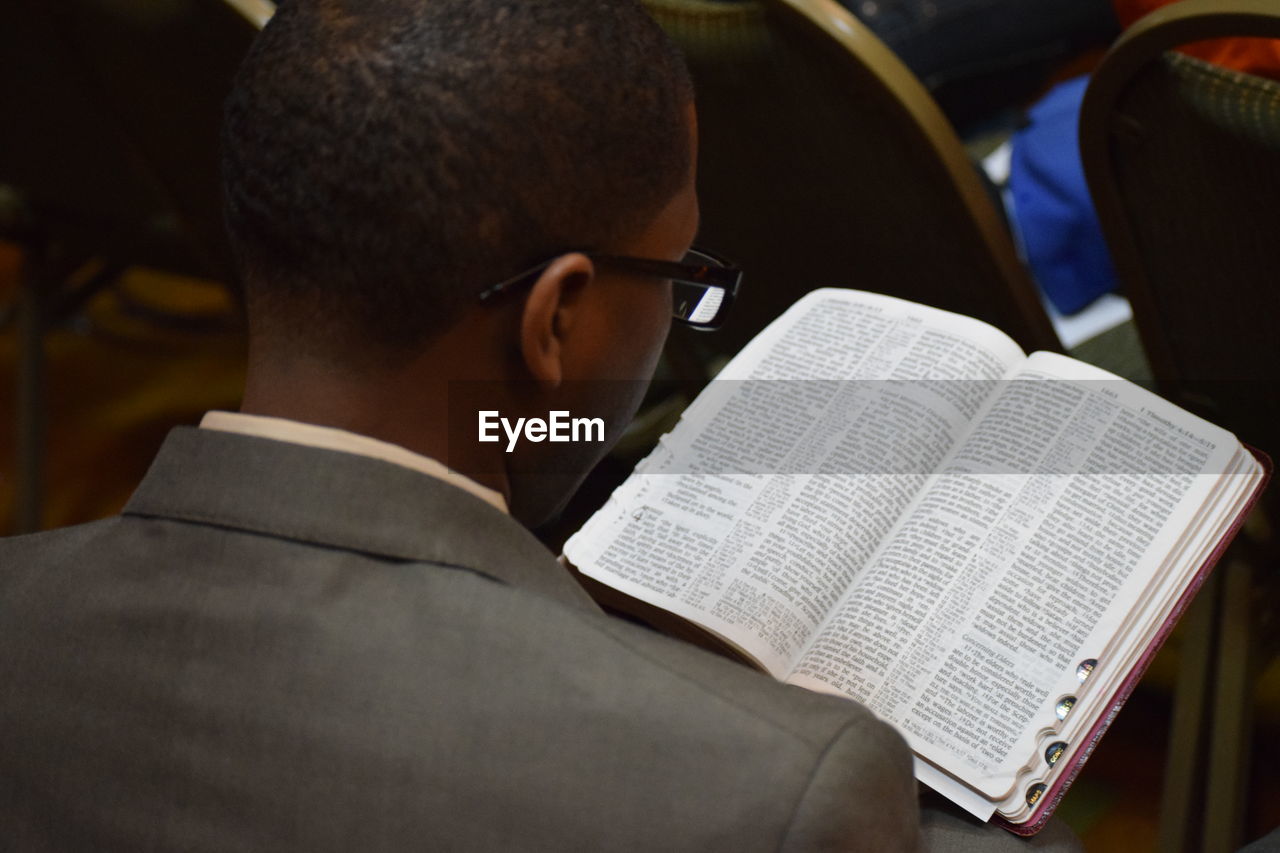 Rear view of man reading bible in church