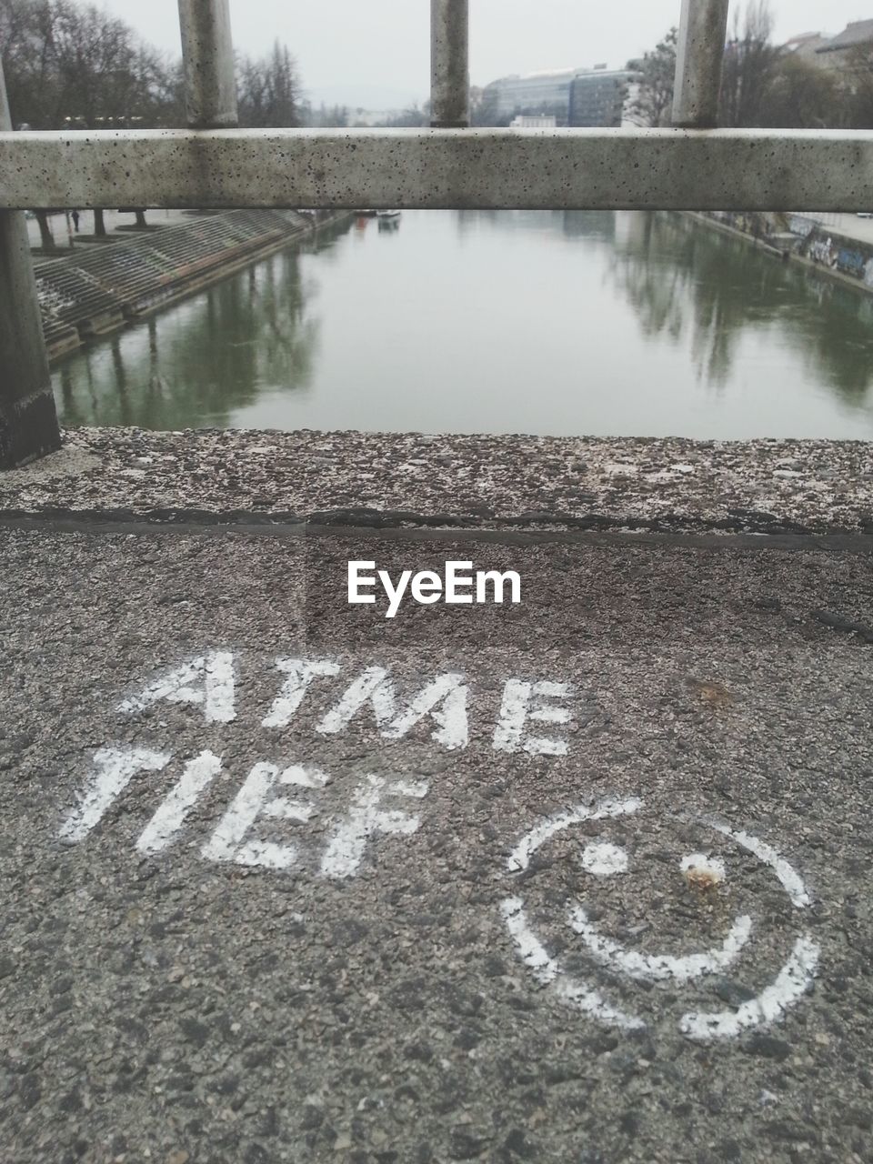 Text and smiley face on bridge over canal