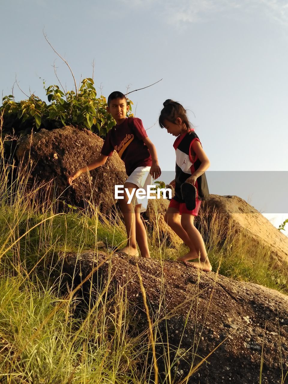 Rear view of people standing on land against sky