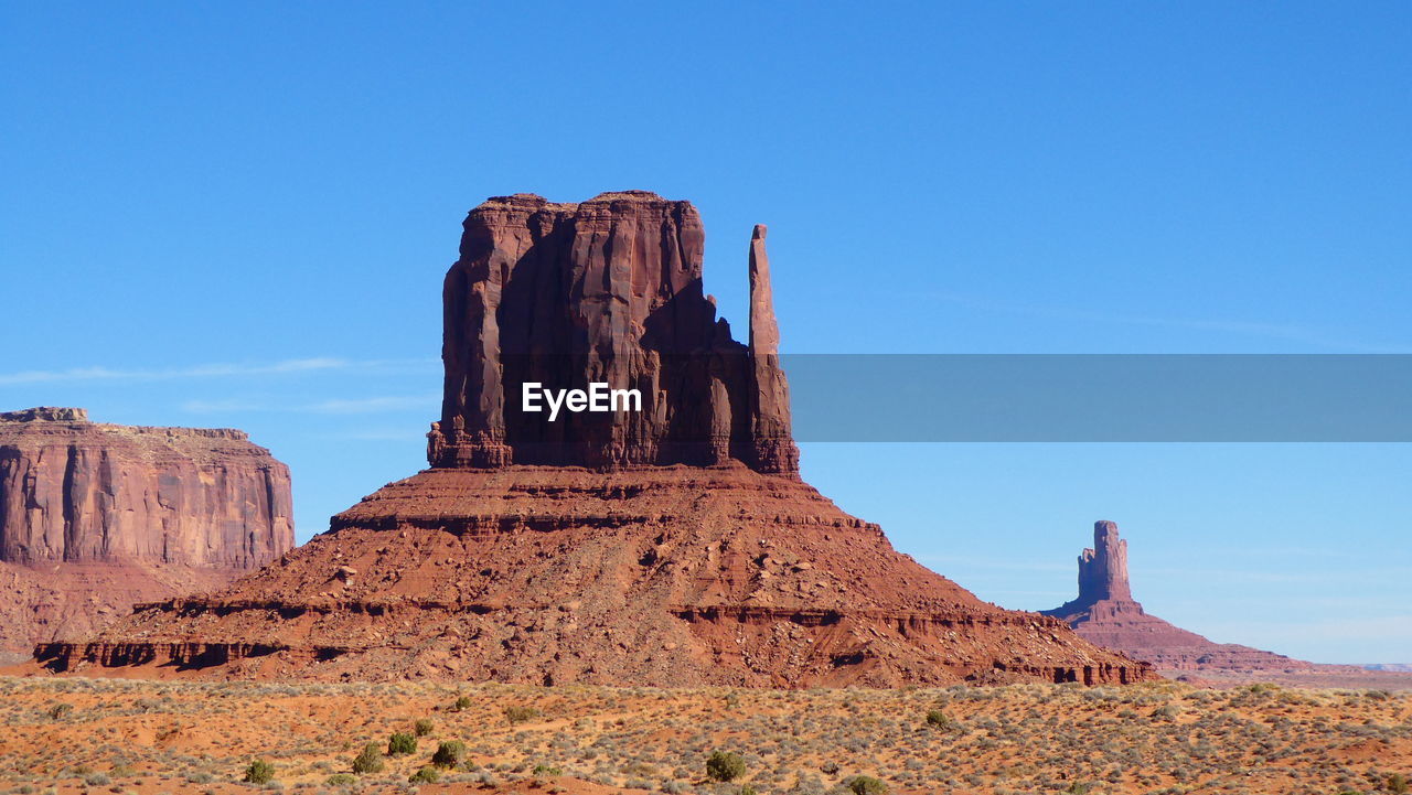 Monument valley rock formation against a clear blue sky