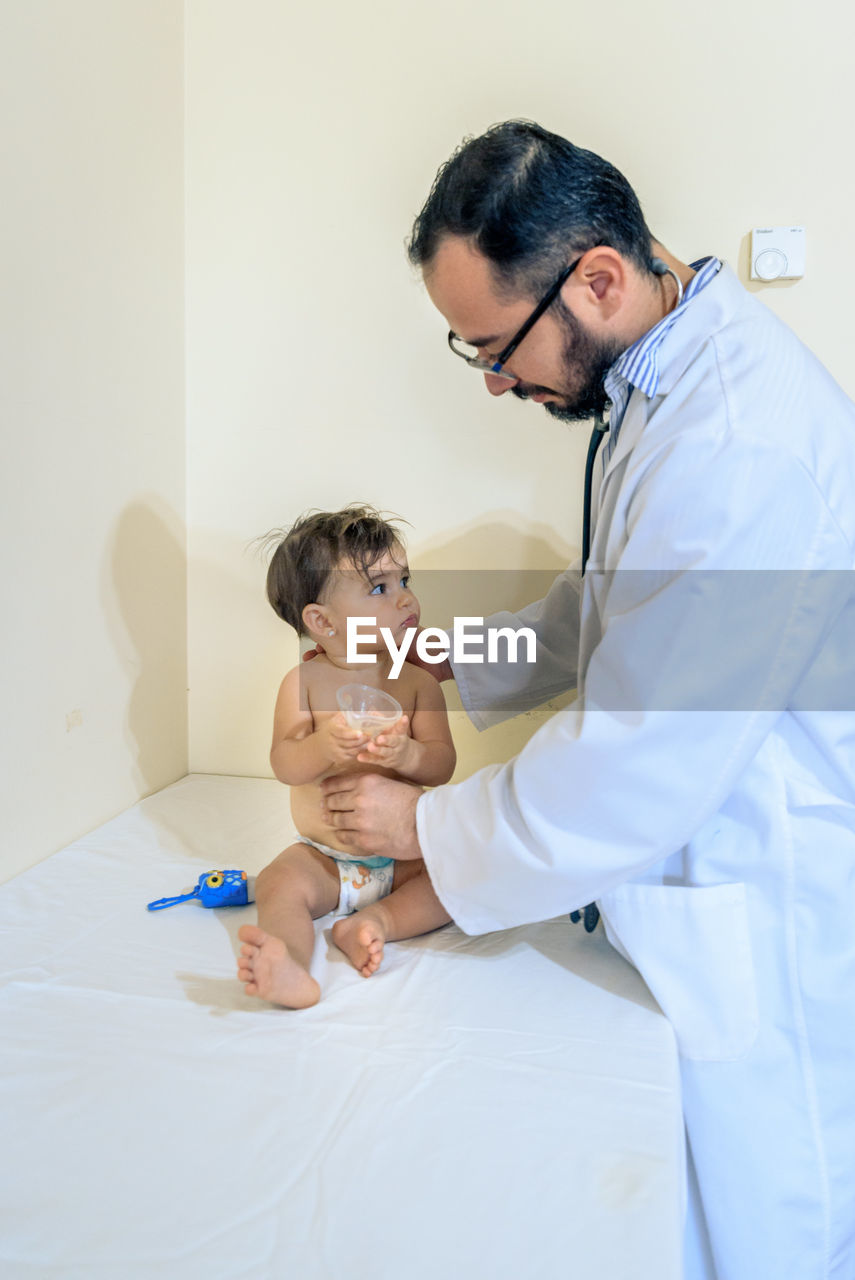 Doctor observing a one-year-old baby