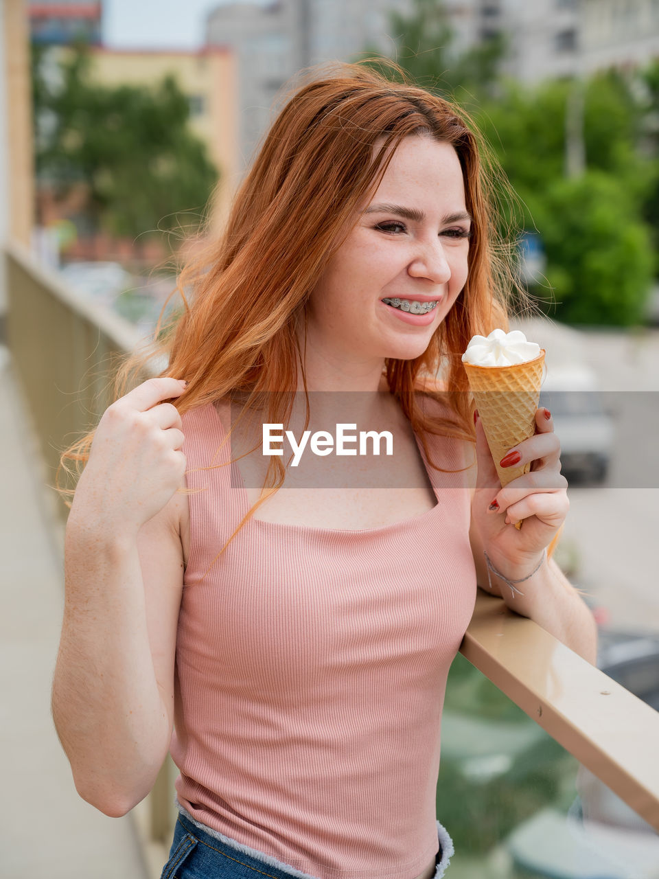 BEAUTIFUL YOUNG WOMAN WITH ICE CREAM OUTDOORS