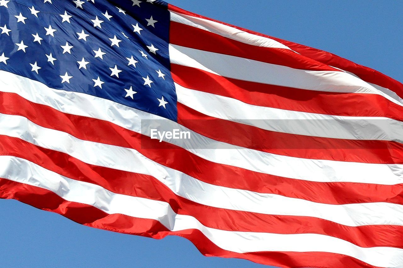 Close-up of american flag against sky