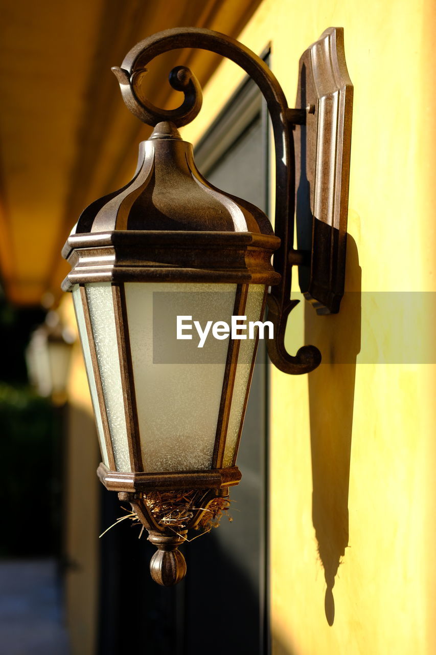 CLOSE-UP OF LANTERN HANGING AGAINST WALL