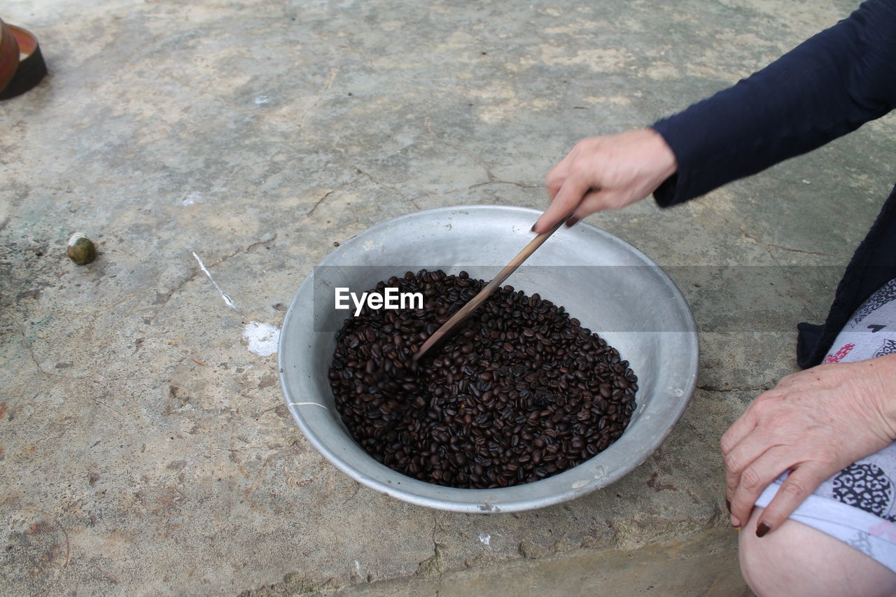 HIGH ANGLE VIEW OF MAN PREPARING FOOD IN CONTAINER