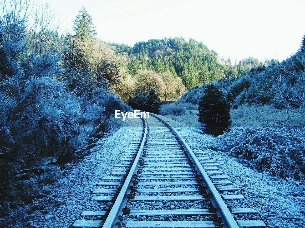 Snow covered railroad tracks against sky