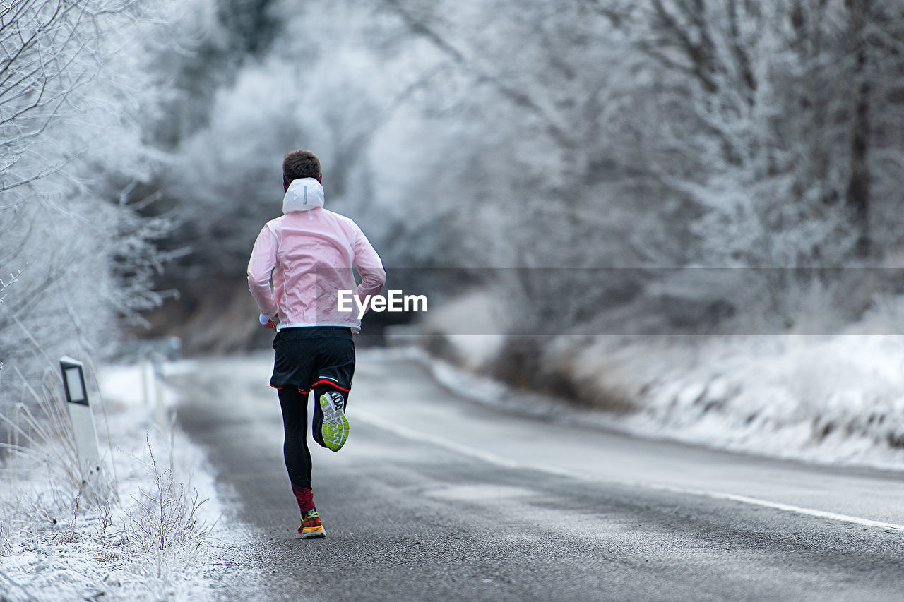 Rear view of man running on road