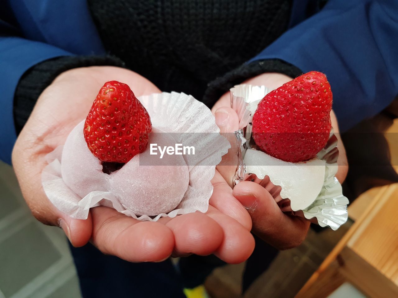 Midsection of woman holding desserts on hand 