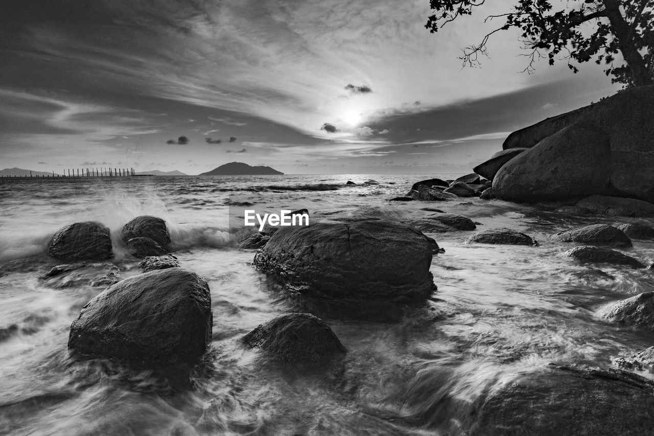 water, sea, land, sky, rock, beach, wave, scenics - nature, nature, beauty in nature, black and white, coast, ocean, wind wave, cloud, motion, monochrome photography, environment, monochrome, shore, seascape, long exposure, no people, outdoors, tranquility, landscape, coastline, horizon over water, travel destinations, travel, tranquil scene, water sports, sports