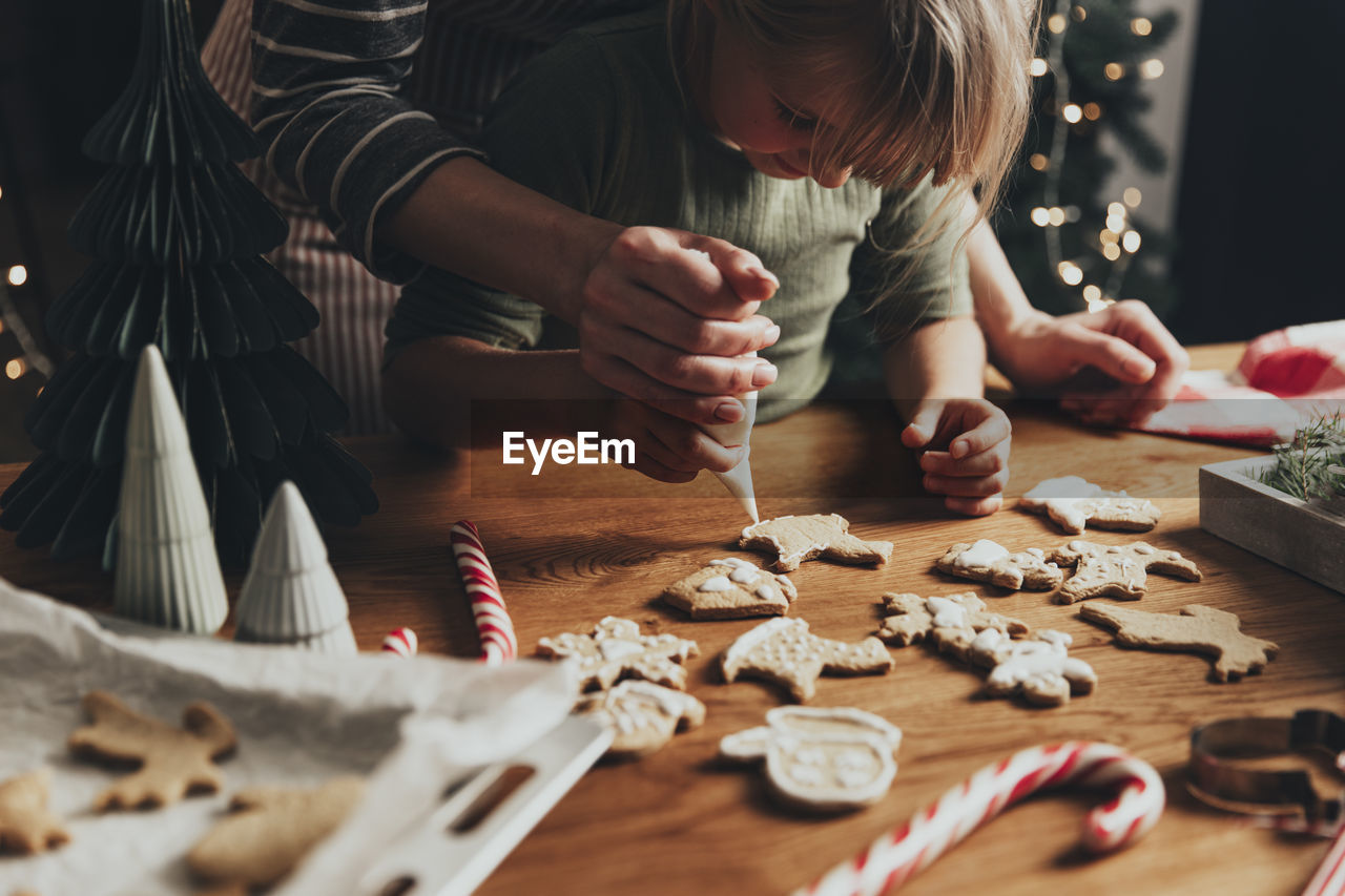 Christmas, new year food preparation. xmas gingerbread cooking, decorating cookie with icing, mastic