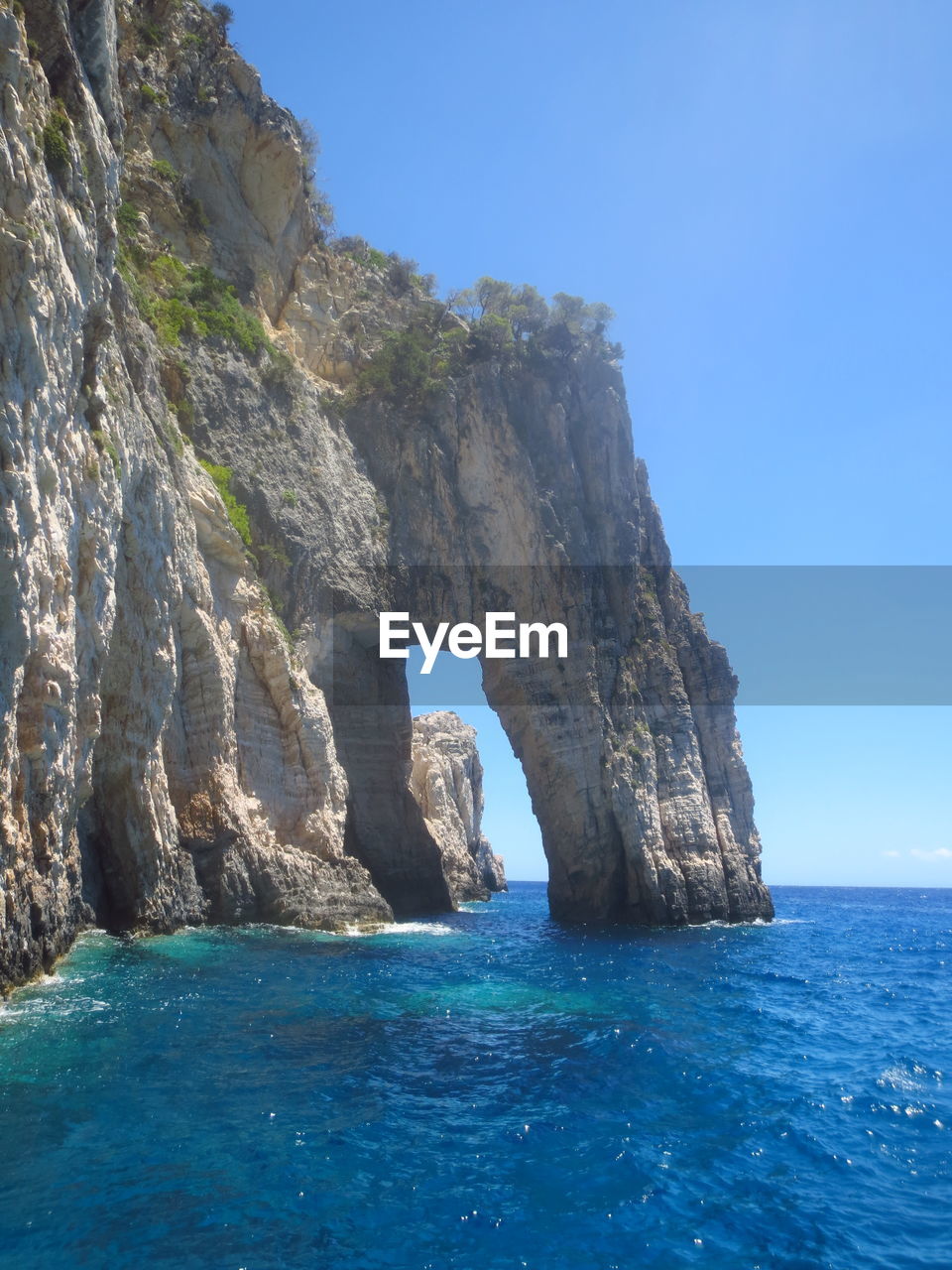 ROCK FORMATION IN SEA AGAINST CLEAR SKY